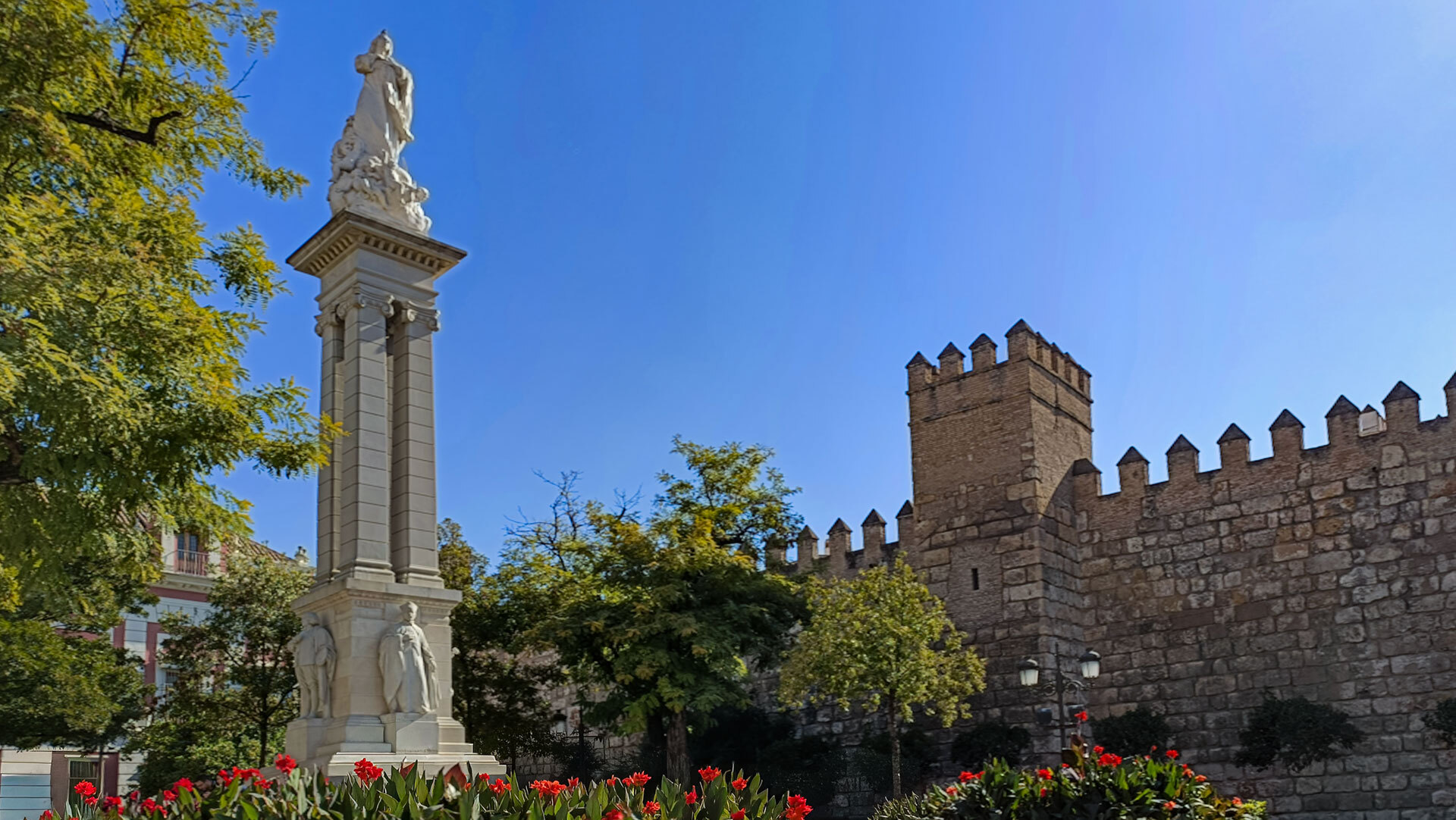 Die Plaza del Triunfo in Sevilla mit dem Monumento a la Inmaculada Concepción und den historischen Mauern des Real Alcázar